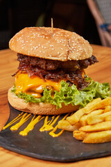 Delicious burger with double meat, caramelized onion, fresh vegetables and potatoes