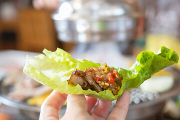 Lettuce wrap with grilled meat. Grilled meat and vegetables being grilled on barbecue grill in a...