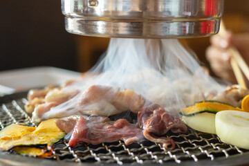 Grilled meat and vegetables being grilled on barbecue grill in a restaurant. 