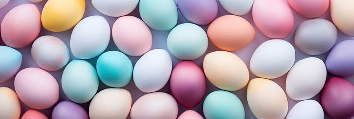 Top view of colorful Easter eggs on soft purple background. Multicolor painted eggs banner on light...