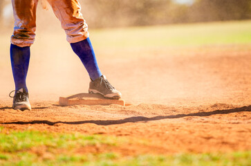 Baseball player on third base. Baseball player wearing blue socks standing on a base