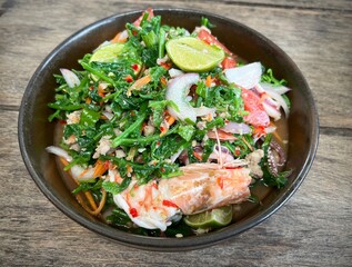 Table top view spicy diplazium esculentum seafood salad or yum pak khut in Thailand.