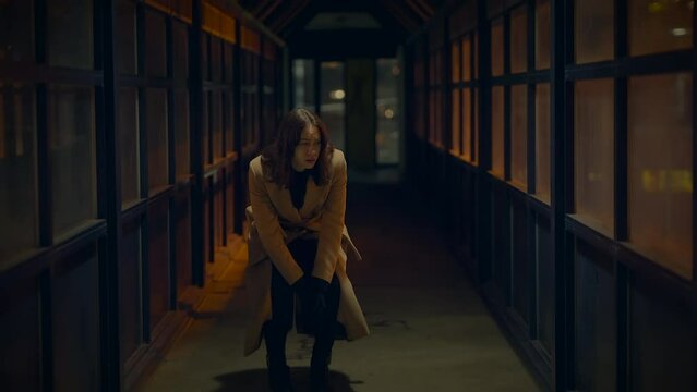 Sad Woman Thinking Hopeless and Lonely Inside Urban Hallway at Night Light