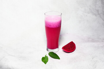Isolated of fresh juice Buah Naga Merah or red dragon fruit on a tall glass in bright mood on white background