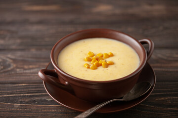 Delicious creamy corn soup in ceramic bowl on the table. Vegetarian food