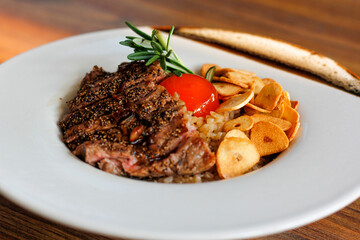 Beef Fried Rice Topping with Wagyu Beef Crispy fried garlic and pickled egg yolks in a white plate on a wooden table