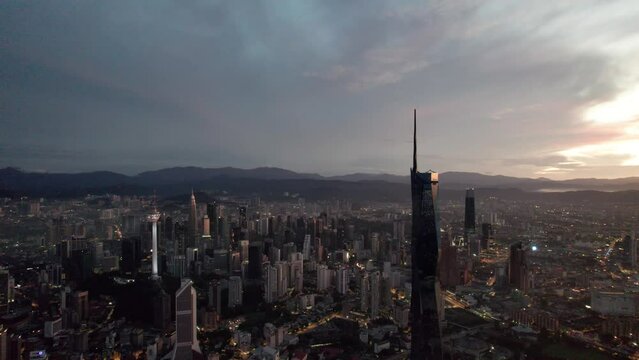 Establishing aerial cinematic b-roll shot of sunrise at Kuala Lumpur city skyline with highest building in Asia. 