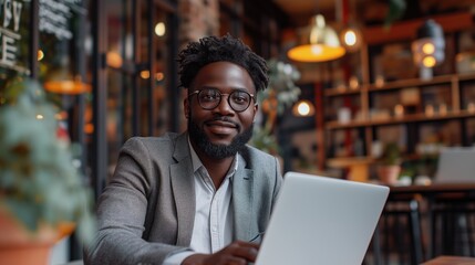 Successful Black Businessman Working on Laptop Computer in His Big City Office.