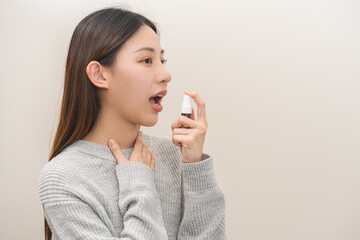 Health care treatment sore throat concept, sick pain asian young woman have cough symptom holding medicine bottle, using spray in mouth to protect disease from bacteria, illness from virus infection. - obrazy, fototapety, plakaty