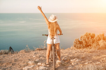 Woman travel bike sea. Happy woman cyclist sitting on her bike, enjoying the beautiful mountain and...