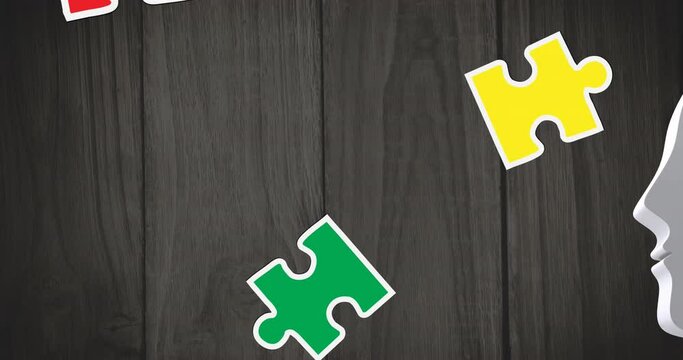 Animation of multi coloured puzzle pieces over wooden background