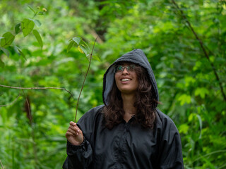 Une femme se balade dans une forêt humide et s'amusant avec une brindille