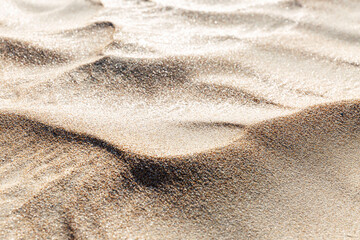 The wavy sandy surface of the dune. Rest and relaxation at a resort by the sea. Close-up. Background. Space for text.