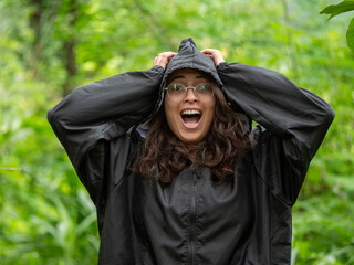 Perdu dans la for&ecirc;t, une femme habill&eacute;e d'un imperm&eacute;able panique