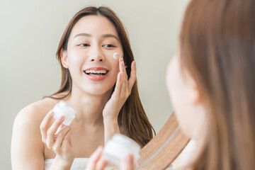 Facial beauty skin care, smile of pretty asian young woman in bathrobe looking at mirror, hand...