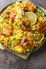 Fragrant seafood pilaf with shrimp and a lot of herbs such as dill, green onions, cilantro close-up on a plate on the table. Vertical top view from above
