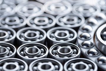 Surface laid with steel ball radial bearings for large machinery, equipment and mechanical engineering close-up. Bearings close-up in gray silver shades with blurred background.
