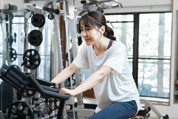Fototapeta premium バイクを使い鍛えるトレーニングをする女性