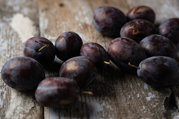 Fototapeta premium Ripe plums on a wooden old background, horizontal format, macro