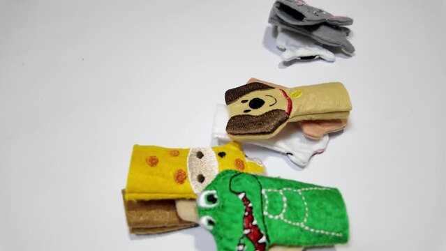 Wild and domestic animals shaped cognitive puppets for children are dropping down on a white background.