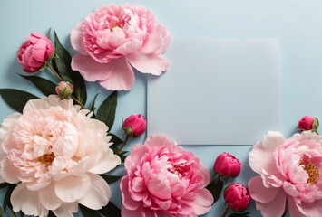 Greeting card mockup and beautiful pink peonies flowers frame on pastel blue background with copy space. Empty blank sheet card mock up for holiday greetings. Valentine's day, Mother's day, birthday