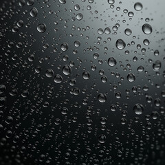 Crystal Clarity: Macro Photography of Raindrops on Dark Glass, Reflective Water Droplets Background