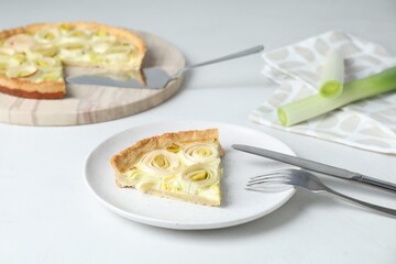 Piece of tasty leek pie served on white table
