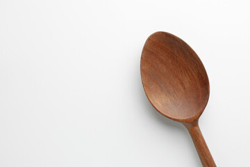 One wooden spoon on white background, top view. Space for text