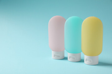 Cosmetic travel kit on light blue background, space for text. Bath accessories