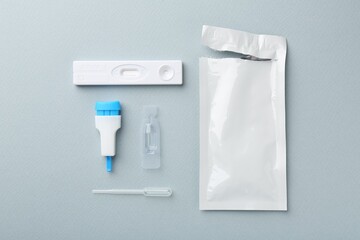 Disposable express test kit on light blue background, flat lay