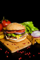 Hamburger with meat patty and cheese. bacon and fresh vegetables