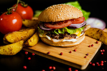 Hamburger with meat patty and cheese. bacon and fresh vegetables