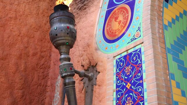 Burning torch on wall with arabic tiling bright ornament