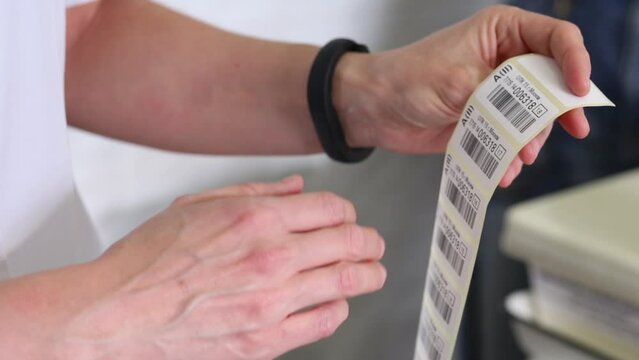 Female medical laboratory worker shows stickers with bar codes