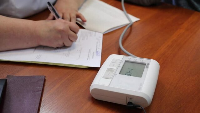 medical laboratory worker hands fill form and automatic tonometer