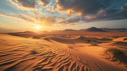 Foto op Canvas  the sun sets over a desert landscape with sand dunes and mountains in the distance in the distance is a mountain range in the distance, and a few clouds in the sky. © Olga