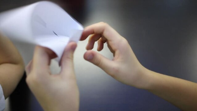 Hands of the girl folds a sheet of paper in the Mobius strip