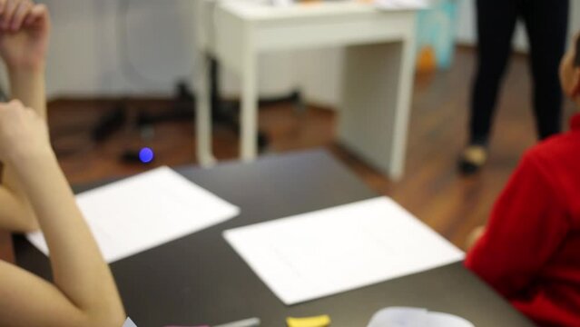 Girl holding lined sheet of paper in the classroom