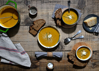 soupe de potiron faite maison servie dans une assiette et des bols avec du pain grillé - obrazy, fototapety, plakaty