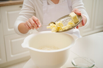 Adding butter to the dough to make a pie. Process of cooking pecan pie in home kitchen for American...