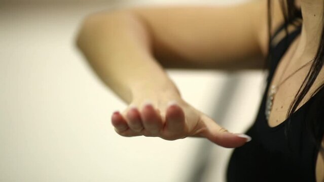Girl model trains to do waving movements by her hands.