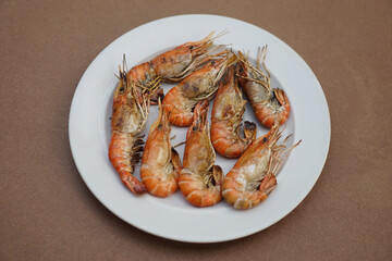 Grilled prawns, river shrimps on white plate. Concept, seafood. Delicious, favorite menu for party or outdoor barbeque or picnic. Healthy food. Ready to eat. Thai eating style.               