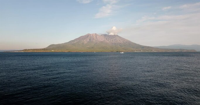噴煙を上げる火山島がある海の風景。