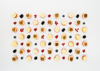 cupcakes and berries laid out on a white background