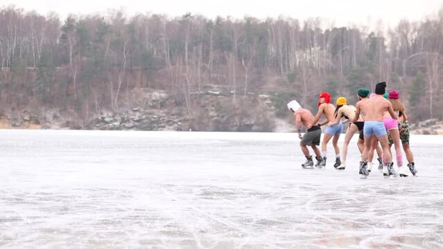 Eight people in underwear skate as train on natural ice rink 