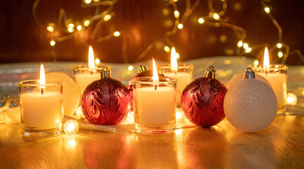 Red Christmas ball and candlelight on a wooden table.