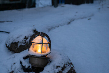 寒い雪の中の暖かいランプの灯り