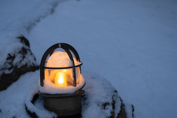寒い雪の中の暖かいランプの灯り