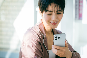 スマホを操作する朝の女性イメージ