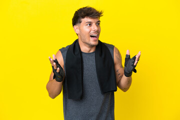 Young sport caucasian man with towel isolated on yellow background with surprise facial expression
